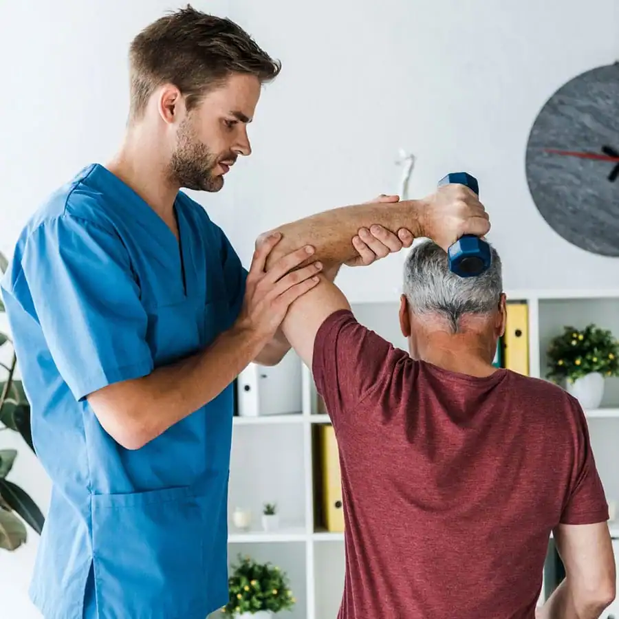 A clinician supporting an older man with a guided strength exercise